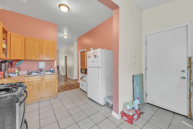 5347 S Racine Ave, Chicago, IL 60609 - kitchen with freestanding refrigerator, range with gas stovetop, light tile patterned flooring, light countertops, and light brown cabinetry