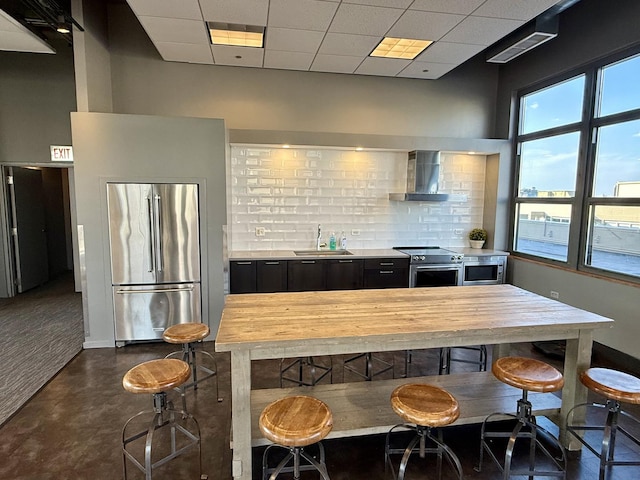 900 N Kingsbury St Unit 861, Chicago, IL 60610 - kitchen featuring high quality appliances, wall chimney exhaust hood, dark cabinets, backsplash, and a kitchen breakfast bar