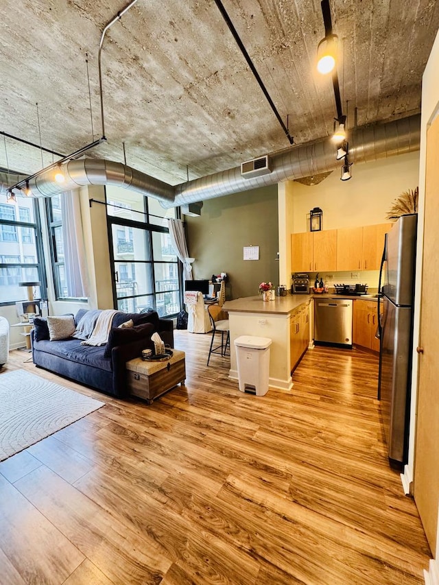 900 N Kingsbury St Unit 861, Chicago, IL 60610 - kitchen with appliances with stainless steel finishes, a peninsula, light wood-style flooring, open floor plan, and light brown cabinets