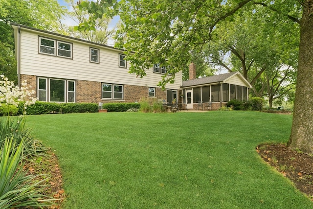 870 Georgetowne Ln, Barrington, IL 60010 - rear view of house featuring a sunroom, brick siding, a lawn, and a chimney