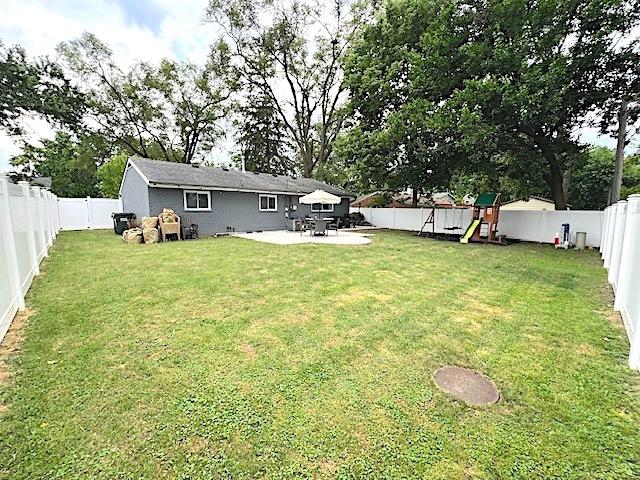 534 White Oak Rd, Bolingbrook, IL 60440 - fenced backyard featuring a playground and a patio area