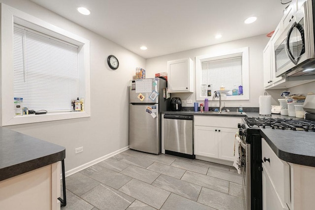 74 Marquette St, Park Forest, IL 60466 - kitchen with stainless steel appliances, dark countertops, white cabinetry, and recessed lighting