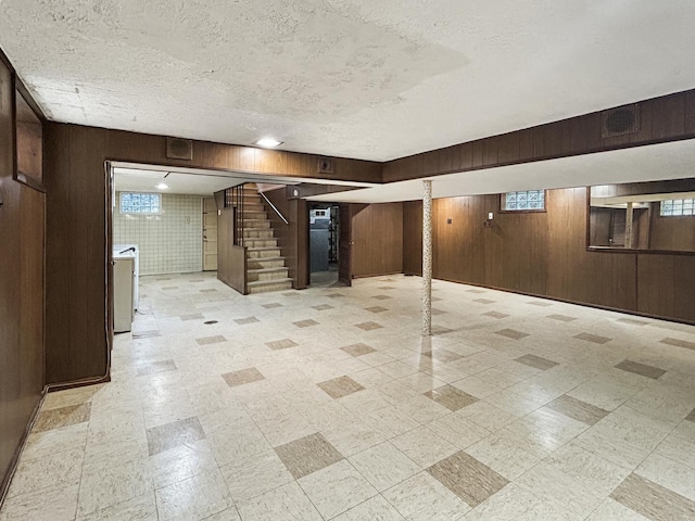 4841 N Natchez Ave, Chicago, IL 60656 - below grade area featuring wood walls, stairway, a textured ceiling, and light floors