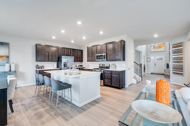2893 Killarny Dr, Elgin, IL 60124 - kitchen with appliances with stainless steel finishes, a breakfast bar area, dark brown cabinetry, light wood finished floors, and recessed lighting