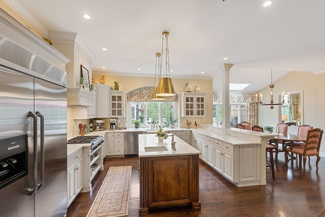 590 Merri Oaks Rd, Barrington Hills, IL 60010 - kitchen featuring stainless steel appliances, a peninsula, glass insert cabinets, decorative backsplash, and decorative light fixtures