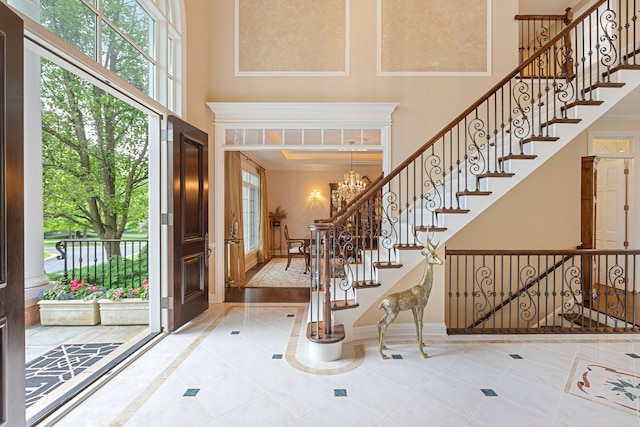 590 Merri Oaks Rd, Barrington Hills, IL 60010 - tiled entrance foyer featuring a high ceiling, inlaid floor details, a chandelier, and stairway