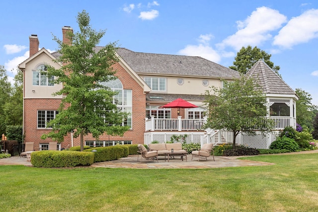 590 Merri Oaks Rd, Barrington Hills, IL 60010 - back of house featuring outdoor lounge area, brick siding, a chimney, a yard, and a patio area