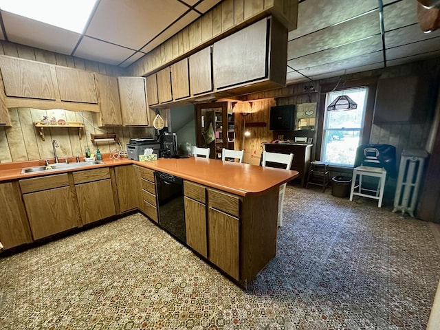 605 Washington St, Prophetstown, IL 61277 - kitchen with dishwasher, a peninsula, a paneled ceiling, wood walls, and light countertops