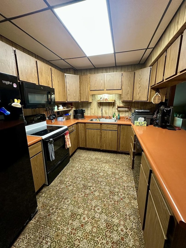 605 Washington St, Prophetstown, IL 61277 - kitchen featuring black appliances, a paneled ceiling, light countertops, and brown cabinets