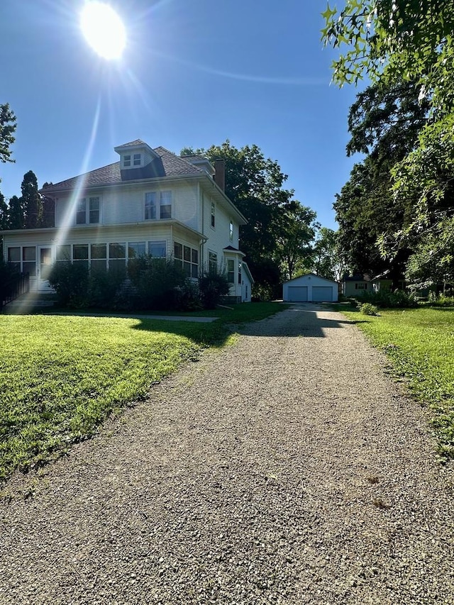 605 Washington St, Prophetstown, IL 61277 - view of front of house with a detached garage, a chimney, a front yard, and an outdoor structure
