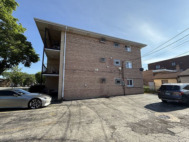 5925 W Montrose Ave Unit 3C, Chicago, IL 60634 - view of property exterior featuring uncovered parking and brick siding