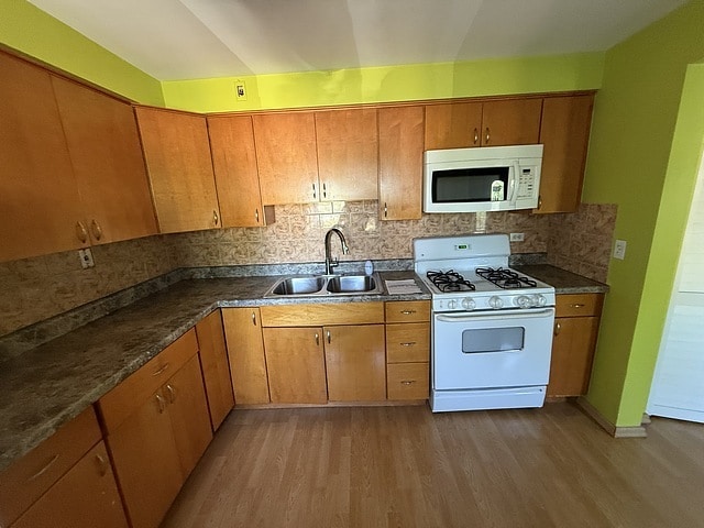 5925 W Montrose Ave Unit 3C, Chicago, IL 60634 - kitchen featuring white appliances, wood finished floors, and brown cabinetry