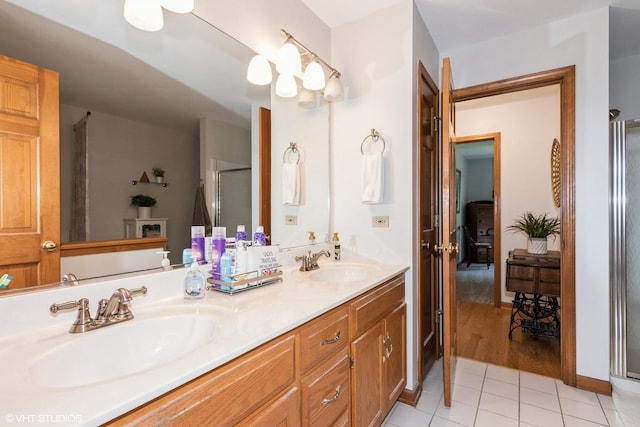 202 Woodboro Dr, West Chicago, IL 60185 - bathroom featuring tile patterned floors, double vanity, and a shower with door