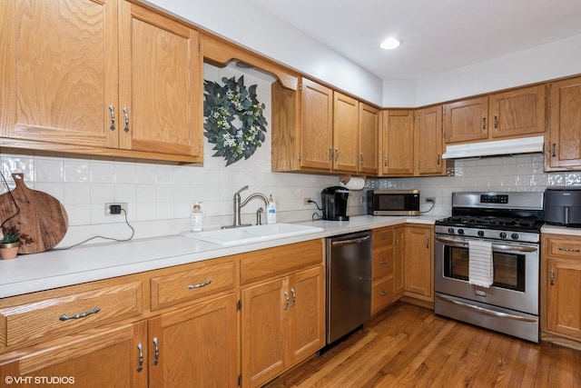 202 Woodboro Dr, West Chicago, IL 60185 - kitchen featuring under cabinet range hood, appliances with stainless steel finishes, light countertops, backsplash, and wood finished floors