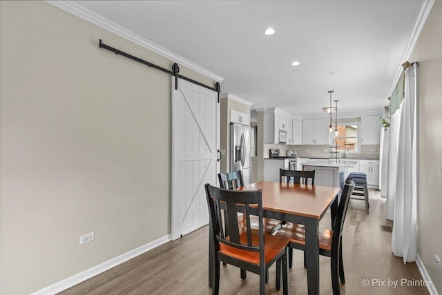 218 Foxmoor Rd, Fox River Grove, IL 60021 - dining space featuring crown molding, wood finished floors, a barn door, and recessed lighting