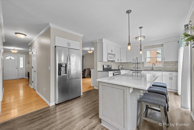 218 Foxmoor Rd, Fox River Grove, IL 60021 - kitchen with appliances with stainless steel finishes, wood finished floors, tasteful backsplash, and crown molding