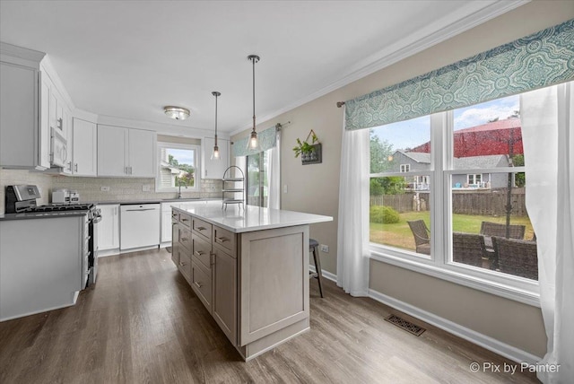 218 Foxmoor Rd, Fox River Grove, IL 60021 - kitchen with white appliances, wood finished floors, ornamental molding, decorative backsplash, and a kitchen island with sink