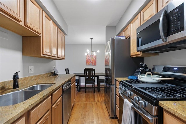 1415 W Lunt Ave Unit 402, Chicago, IL 60626 - kitchen with appliances with stainless steel finishes, light wood-style flooring, light stone countertops, decorative light fixtures, and a chandelier