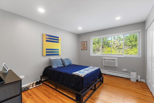 1415 W Lunt Ave Unit 402, Chicago, IL 60626 - bedroom featuring a wall mounted AC, light wood-type flooring, recessed lighting, baseboard heating, and a closet