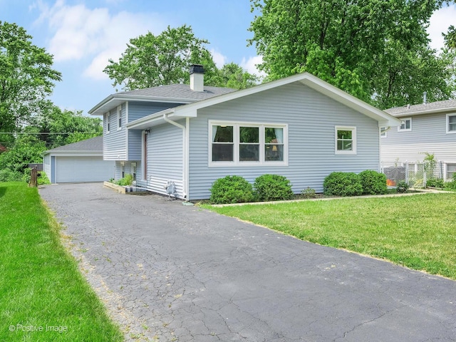 3916 N Adams St, Westmont, IL 60559 - tri-level home featuring a chimney, a front yard, roof with shingles, and a detached garage
