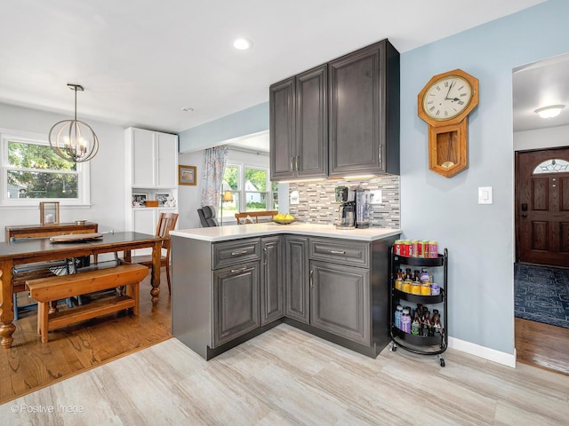3916 N Adams St, Westmont, IL 60559 - kitchen with gray cabinets, a peninsula, light wood-style floors, light countertops, and backsplash