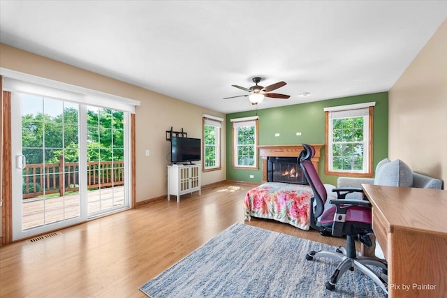 906 Ridgewood Dr, Cary, IL 60013 - bedroom featuring multiple windows, access to exterior, wood finished floors, and a glass covered fireplace