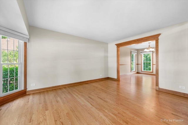 906 Ridgewood Dr, Cary, IL 60013 - empty room with light wood finished floors, a chandelier, plenty of natural light, and vaulted ceiling