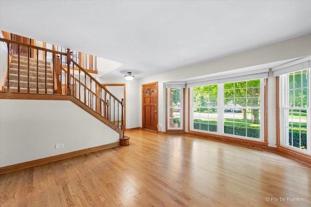 906 Ridgewood Dr, Cary, IL 60013 - unfurnished living room with wood finished floors, stairway, and plenty of natural light