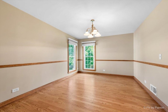 906 Ridgewood Dr, Cary, IL 60013 - spare room featuring a chandelier and light wood-style floors