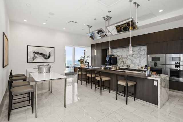 363 E Wacker Dr Unit 2503, Chicago, IL 60601 - kitchen with modern cabinets, a kitchen breakfast bar, a large island with sink, a towering ceiling, and stainless steel double oven