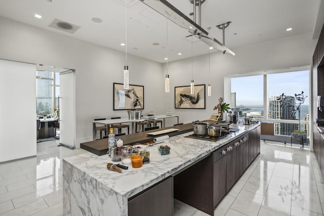 363 E Wacker Dr Unit 2503, Chicago, IL 60601 - kitchen featuring stainless steel gas stovetop, a spacious island, modern cabinets, a towering ceiling, and light marble finish floors
