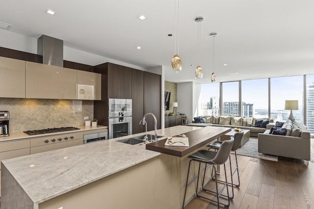 363 E Wacker Dr Unit 2503, Chicago, IL 60601 - kitchen featuring wood-type flooring, modern cabinets, a large island with sink, decorative backsplash, and stainless steel double oven