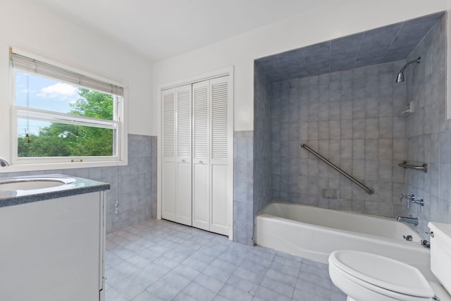 2326 Hancock St, Rockford, IL 61103 - bathroom featuring tile walls, vanity, tub / shower combination, tile patterned flooring, and a closet