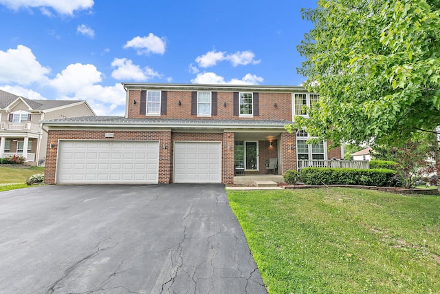 1285 Mallard Ln, Hoffman Estates, IL 60192 - view of property featuring asphalt driveway, a front lawn, brick siding, and covered porch