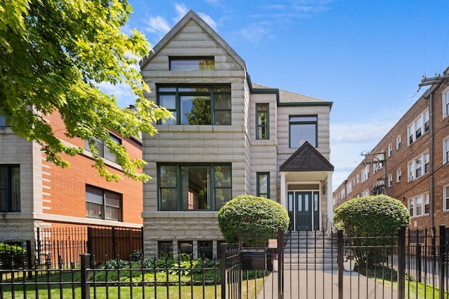 925 E 49th St, Chicago, IL 60615 - contemporary home featuring a fenced front yard, stone siding, a gate, and a shingled roof