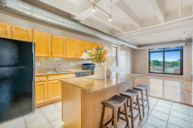 5200 S Ellis Ave Unit 318, Chicago, IL 60615 - kitchen featuring freestanding refrigerator, a center island, rail lighting, a breakfast bar, and light brown cabinets