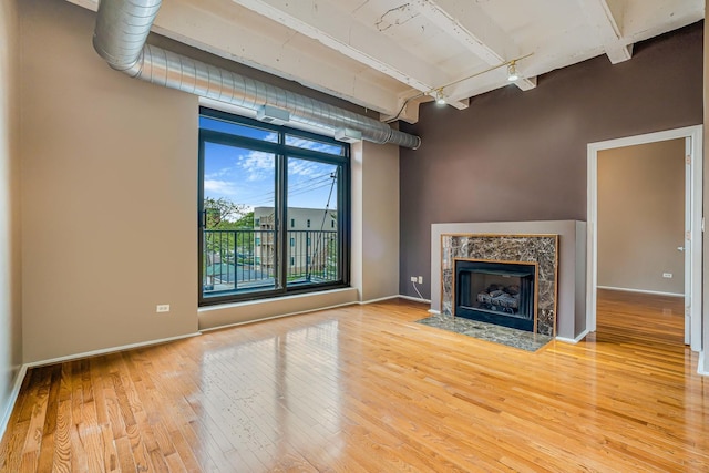 5200 S Ellis Ave Unit 318, Chicago, IL 60615 - unfurnished living room featuring track lighting, light wood-style flooring, beam ceiling, and a premium fireplace