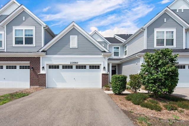 23540 W Bancroft Dr Unit 0, Plainfield, IL 60585 - traditional-style house with brick siding, an attached garage, and asphalt driveway
