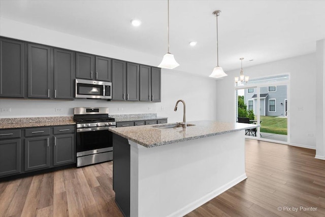 23540 W Bancroft Dr Unit 0, Plainfield, IL 60585 - kitchen with appliances with stainless steel finishes, light stone countertops, wood finished floors, a chandelier, and an island with sink
