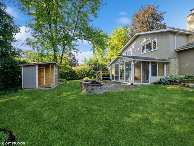 235 S Cedar St, Palatine, IL 60067 - view of grassy yard featuring a sunroom, a storage unit, an outdoor fire pit, and a patio area
