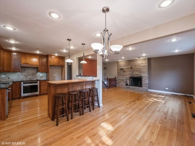 235 S Cedar St, Palatine, IL 60067 - kitchen featuring oven, brown cabinets, open floor plan, a peninsula, and light wood finished floors