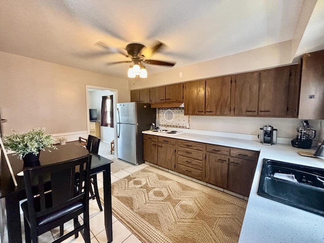 505 Highland St, Belvidere, IL 61008 - kitchen featuring freestanding refrigerator, light countertops, a ceiling fan, light tile patterned flooring, and white cooktop