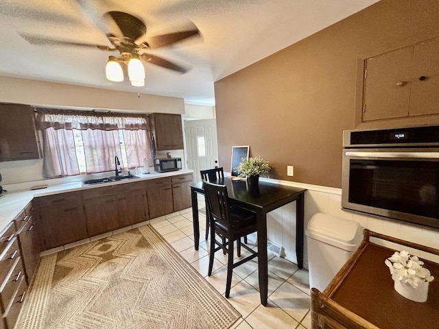 505 Highland St, Belvidere, IL 61008 - kitchen with oven, light countertops, black microwave, ceiling fan, and light tile patterned flooring