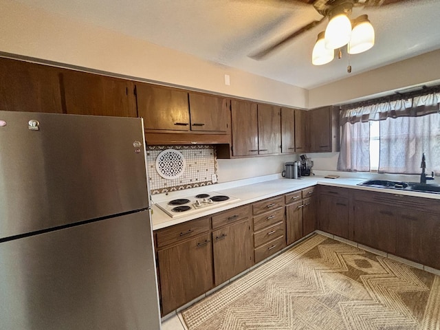 505 Highland St, Belvidere, IL 61008 - kitchen with freestanding refrigerator, white electric cooktop, light countertops, and decorative backsplash