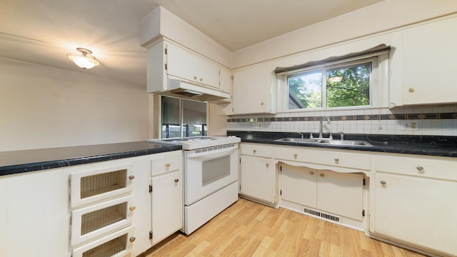 4209 Rotary Rd, Rockford, IL 61109 - kitchen with white range with electric cooktop, decorative backsplash, light wood-style flooring, and dark countertops
