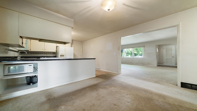 4209 Rotary Rd, Rockford, IL 61109 - kitchen with white appliances, light colored carpet, dark countertops, and backsplash