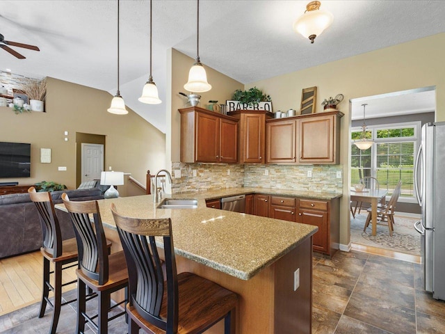 7681 Highlands Dr, Rockford, IL 61102 - kitchen featuring appliances with stainless steel finishes, open floor plan, a peninsula, a ceiling fan, and light stone countertops