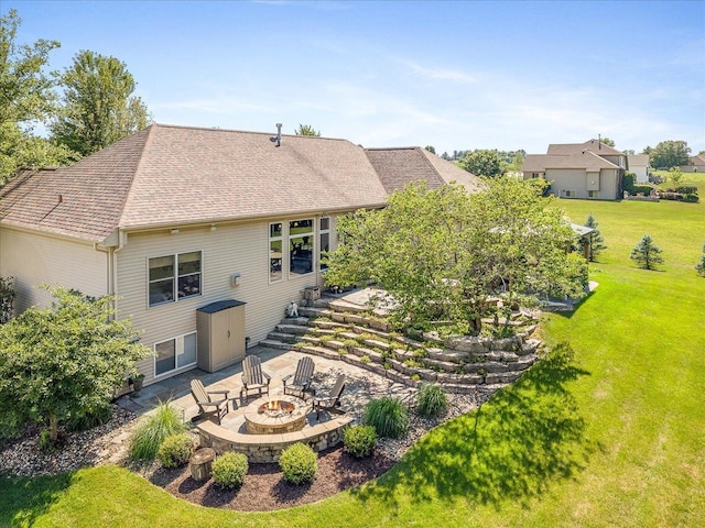 7681 Highlands Dr, Rockford, IL 61102 - back of property featuring an outdoor fire pit, a lawn, a patio area, and roof with shingles