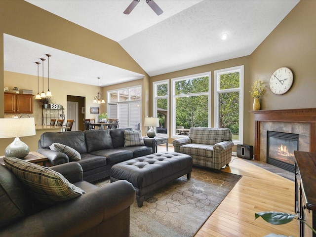 7681 Highlands Dr, Rockford, IL 61102 - living area featuring vaulted ceiling, a fireplace, light wood finished floors, ceiling fan, and a chandelier