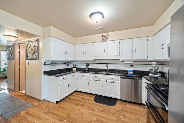 2626 E Martha Pl, Burnham, IL 60633 - kitchen with appliances with stainless steel finishes, white cabinets, and light wood-style flooring
